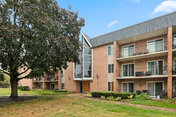 Front view of a multi-story apartment building with balconies.