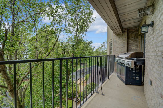 Balcony view with trees and a barbecue grill