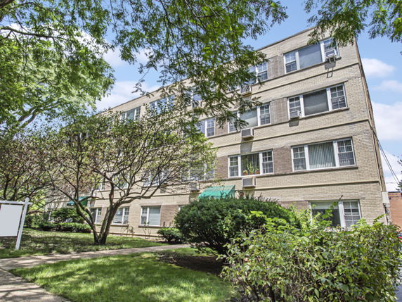 Front view of a multi-story apartment building with brick exterior.