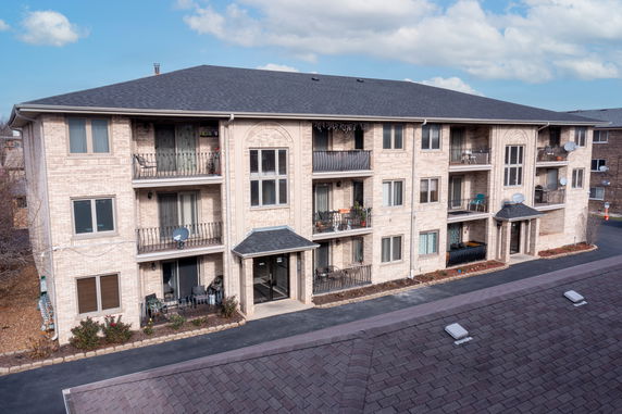 Front view of a multi-story apartment building with balconies.