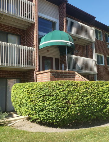 Front view of a multi-story brick apartment building with balconies.
