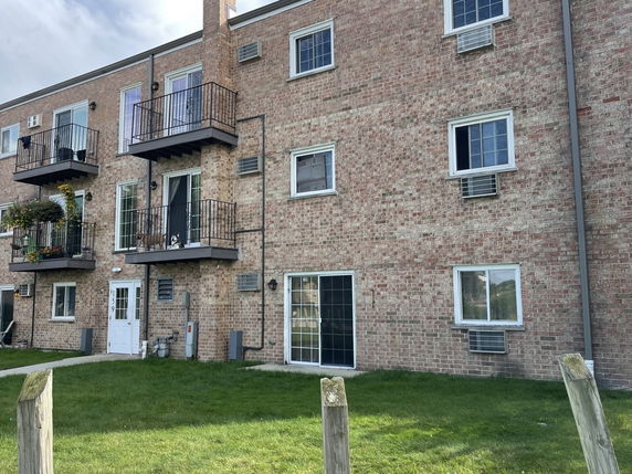 Front view of a multi-story brick building with balconies and windows.