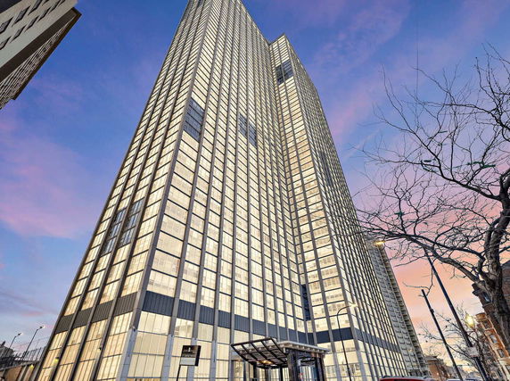 Front view of a tall glass-paneled skyscraper building.