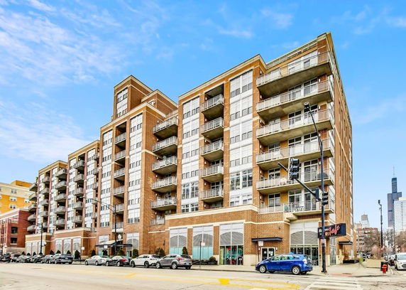 Front view of a multi-story apartment building with balconies.