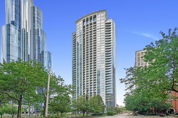 Front view of a tall, modern glass building in an urban setting.