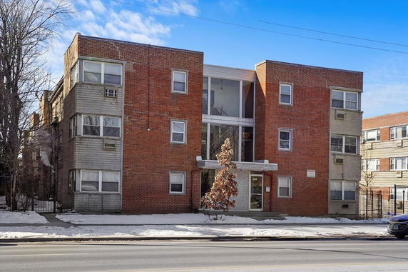 Front view of a three-story brick apartment building.