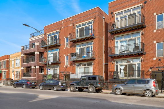 Front view of a multi-story brick building with balconies.