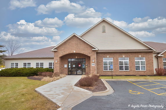 Front view of a one-story brick building with multiple windows and an entrance.