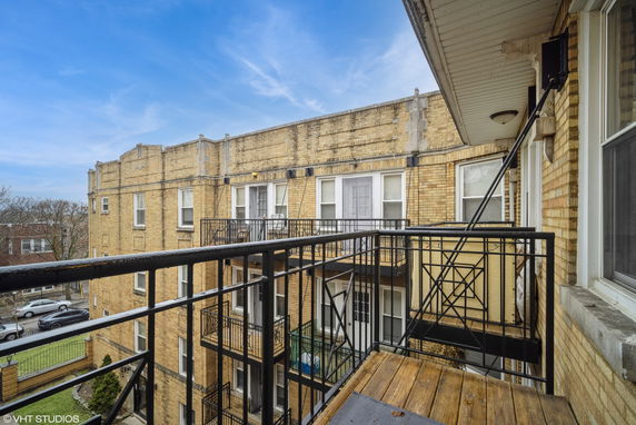 View of a multi-story brick apartment building with balconies and fire escapes.