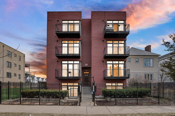 Front view of a modern brick apartment building with balconies.