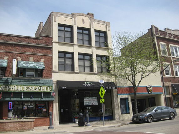 Front view of a three-story commercial building with large windows and a storefront entrance.