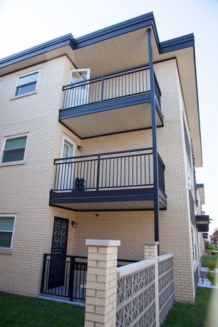 Front view of a multi-story building with balconies and a brick exterior.