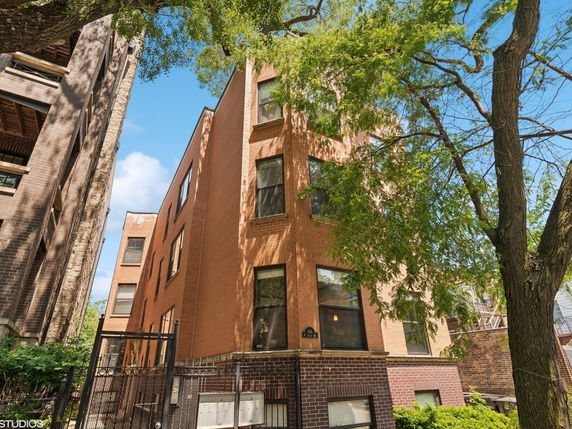 Front view of a multi-story brick building with multiple windows.