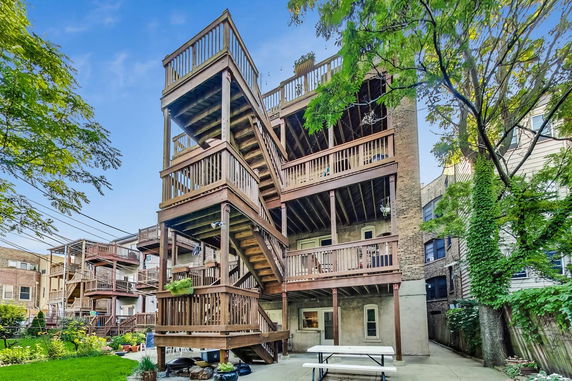 Back view of a multi-story building with wooden balconies and staircases.