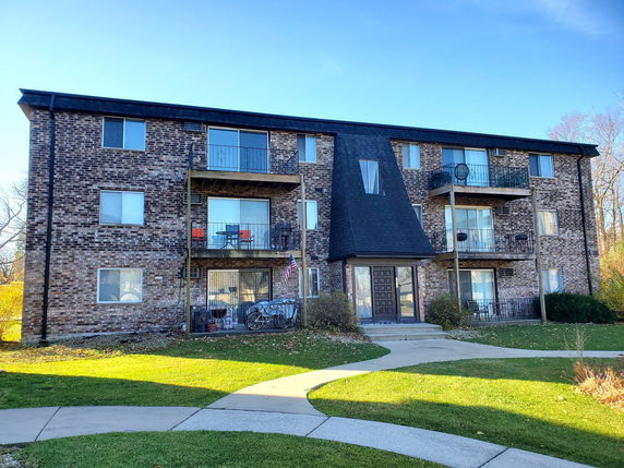 Front view of a three-story apartment building with balconies.