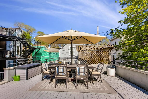 Rooftop area with an outdoor dining set under a large umbrella.