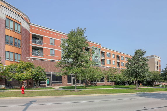 Front view of a multi-story brick building with large windows and balconies.
