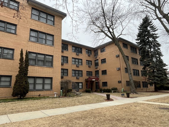 Front view of a three-story brick building with multiple windows and a main entrance.