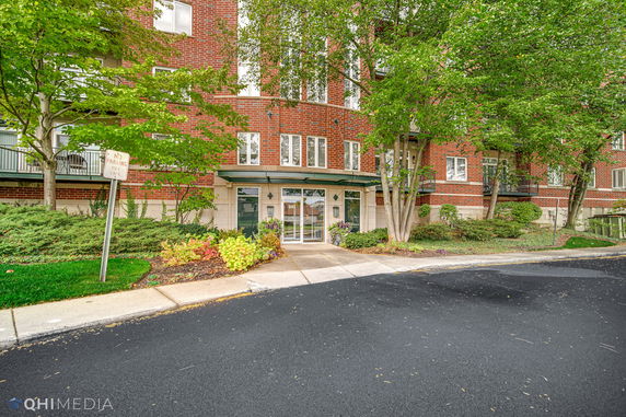 Front view of a red brick multi-story building with glass entrance doors.