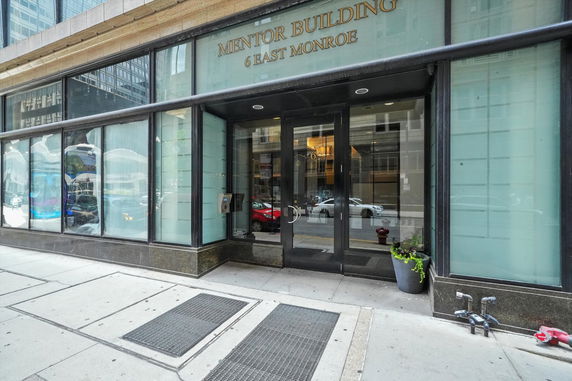 Front view of a building entrance with glass doors and large windows.