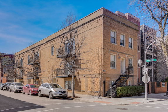 Front view of a two-story apartment building with brick exterior and balconies.