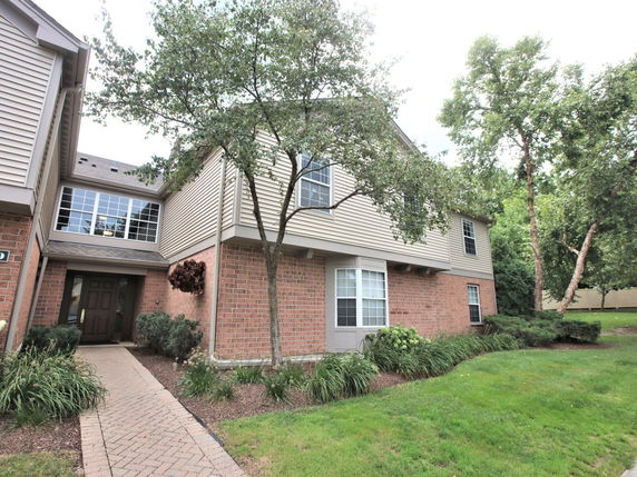Front view of a two-story house with brick and siding exterior.