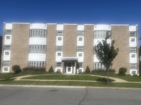 Front view of a multi-story building with brick facade and multiple windows.