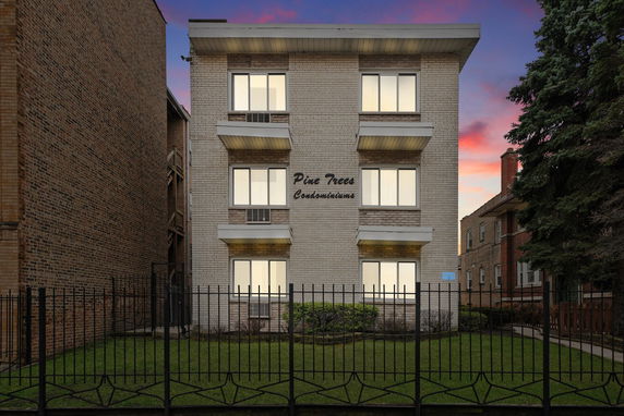 Front view of a multi-story condominium building with a brick exterior.