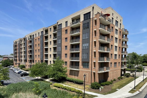 Front view of a multi-story apartment building with balconies.