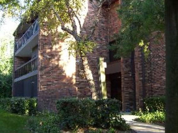 Front view of a brick apartment building with balconies.