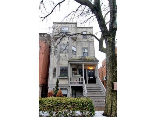 Front view of a multi-story house with a staircase leading to the entrance.