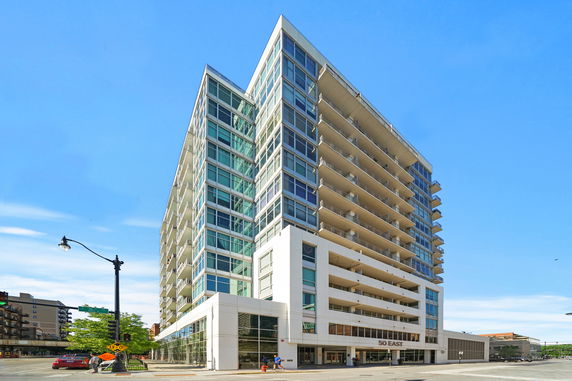 Front view of a multi-story apartment building with glass balconies.