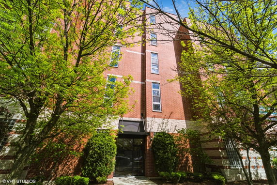 Front view of a multi-story brick building with tall windows and a central entrance.