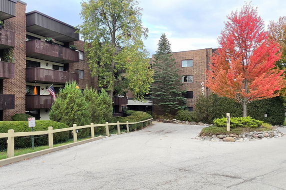 Front view of a multi-story brick apartment building with balconies.