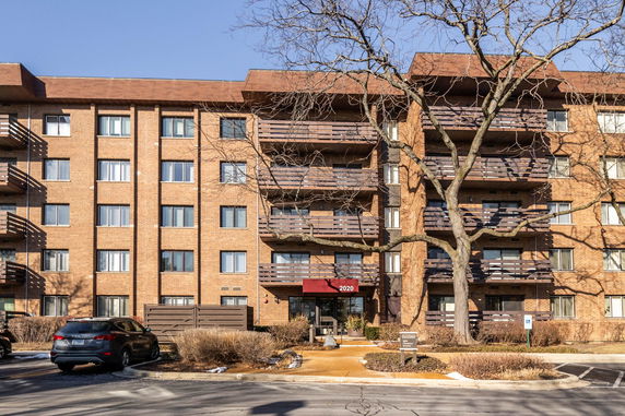 Front view of a multi-story apartment building with balconies.
