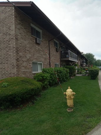 Side view of a two-story brick apartment building with balconies.