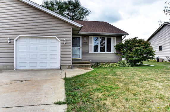 Front view of a single-story house with a white garage door.
