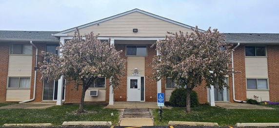 Front view of a two-story building with brick and siding exterior.