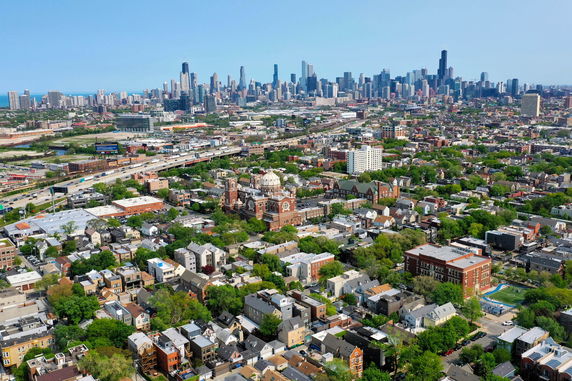 Panoramic view of a cityscape with numerous buildings and a prominent skyline in the background.