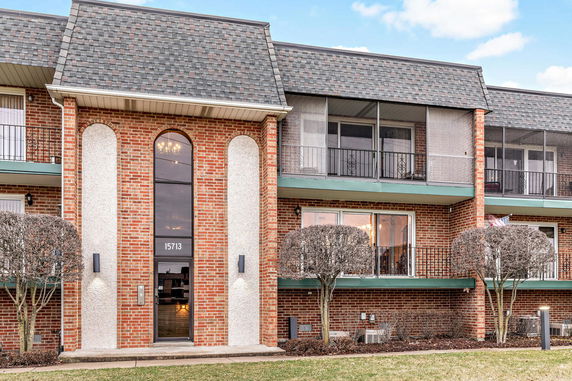 Front view of a two-story brick building with balconies and arched windows.