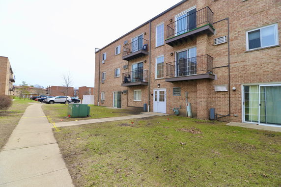 Side view of a three-story apartment building with balconies