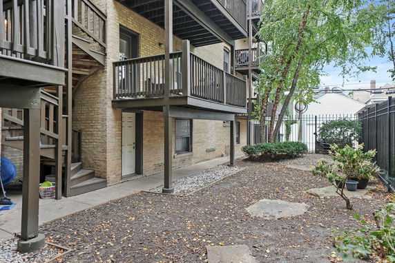 Exterior view of a multi-story building with balconies and wooden railings.
