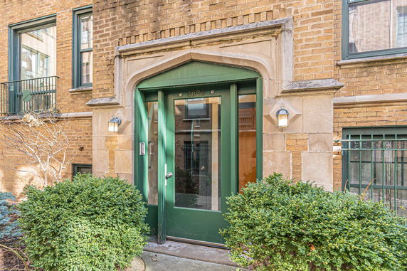 Front view of a building entrance with green door and brick exterior.