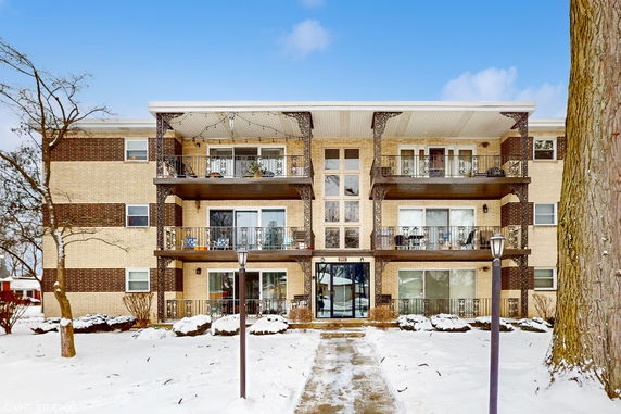 Front view of a multi-story apartment building with balconies.