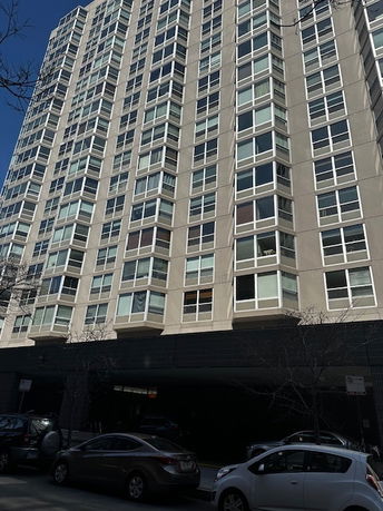 Front view of a multi-story residential building with numerous windows.