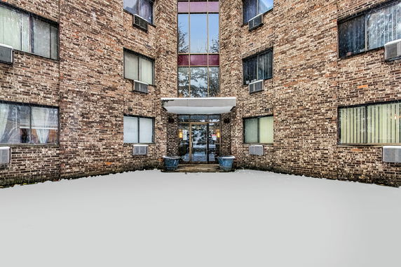 Front view of a brick multi-story building entrance.
