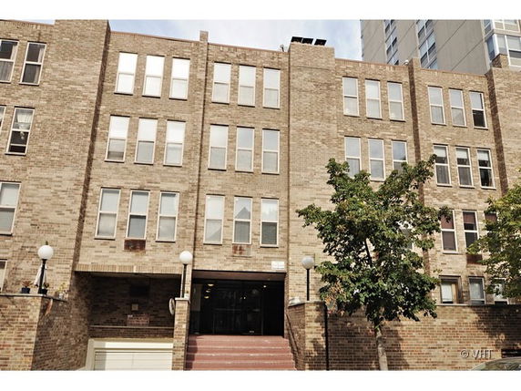 Front view of a multi-story brick apartment building.