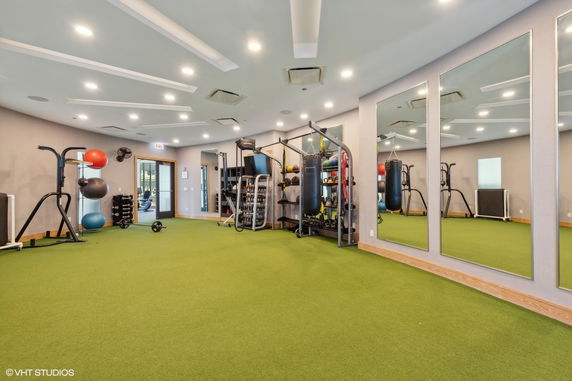 Interior view of a gym with exercise equipment and mirrors.