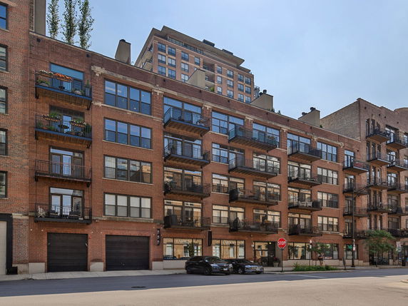 Front view of a multi-story building with balconies and large windows.