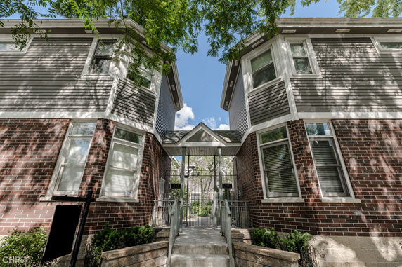 Front view of a two-story residential building with brick and siding exterior.